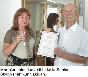 Marinka Laine luovutti Lakelle Senior Skydiversin kunniakirjan.